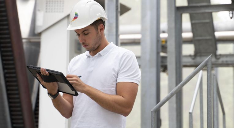 Ein Mitarbeiter von AKQUINET prüft Planungsdaten für ein Rechenzentrum auf einem Tablet.